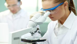 donna ricercatrice al microscopio