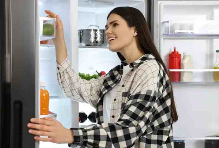 Donna cerca qualcosa in frigo