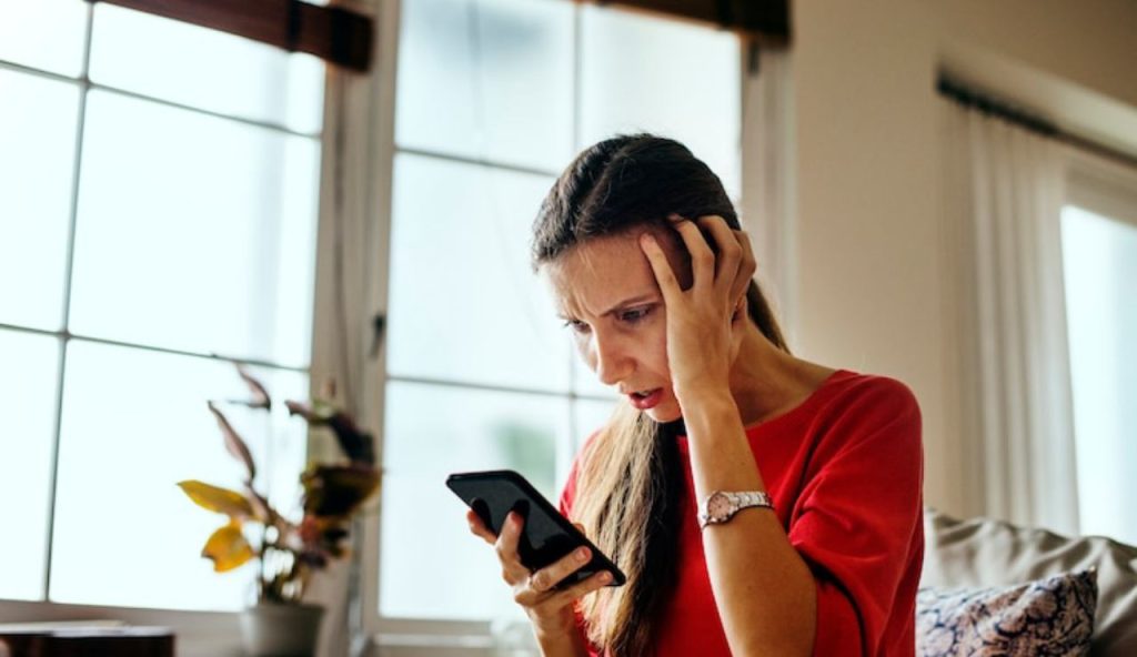Donna sconvolta al cellulare